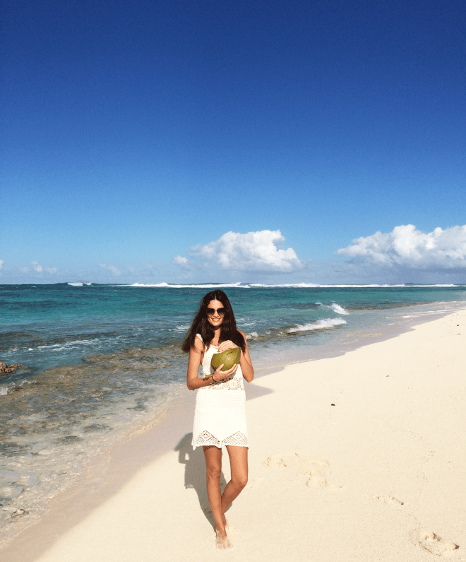 girl eating coconut on beach