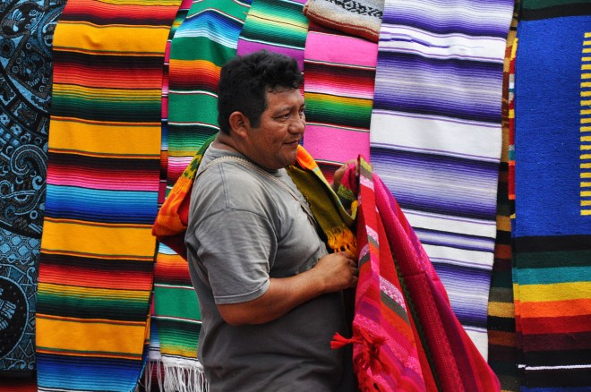 Man selling colourful hand-made rugs mexico