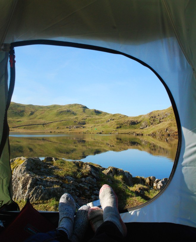 feet in tent with view of lake