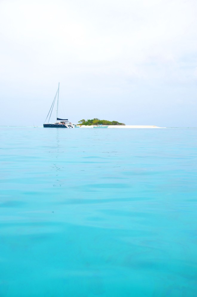 View of sandy spit in the ocean with boat in Jost van Dyke in BVI