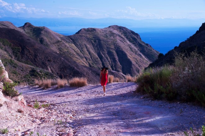 Girl in red dress in front of volcano