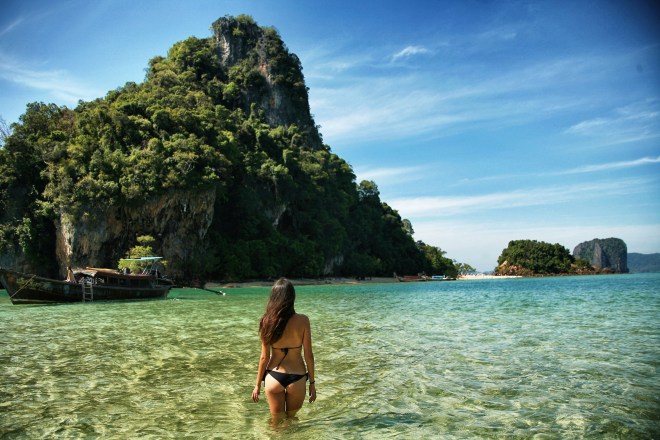 girl in water in front of rock thailand