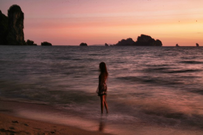 girl at sunset with rocks in thailand