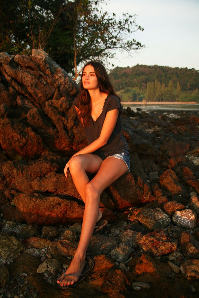 Girl on rocks with sunrise